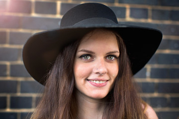 Portrait of young woman with hat and nose ring stud