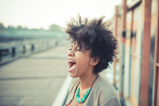 Young woman screaming laughter in city