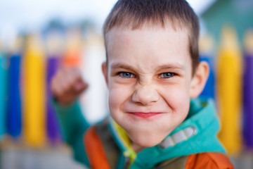aggressive child raised his fist to strike. boy contorted with anger face fighting. selective focus