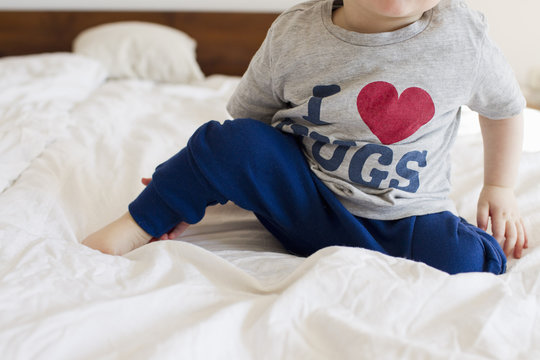 Cropped shot of baby girl wearing pyjamas sitting up in bed