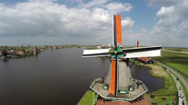 Aerial static bird view of one of windmills of Zaanse Schans one of most popular tourist attractions Netherlands Holland near Amsterdam beautiful drone footage tourists on mill blades turning 4k