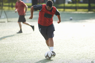 Young man dribbling football