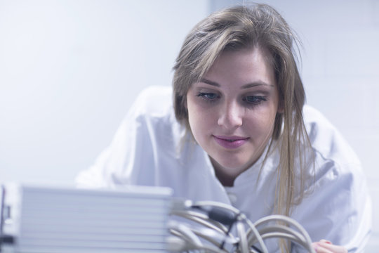 Close up of female scientist in lab using scanning electron microscope