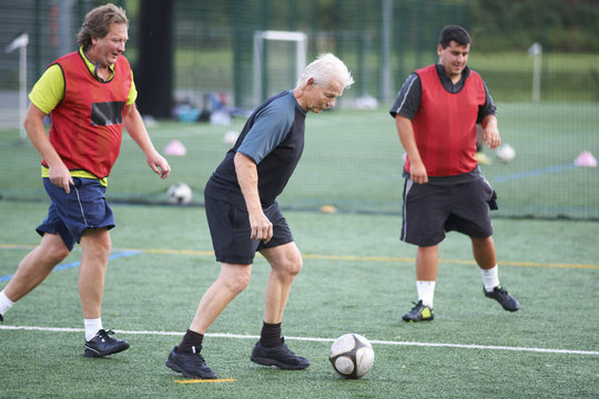 Men playing soccer - Powered by Adobe