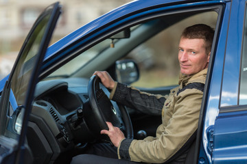 A young man in his car.