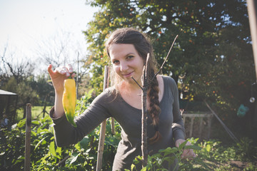 Young woman holding homegrown yellow pepper