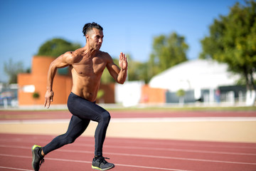 Obraz premium Young muscular man ready to start a track meet.