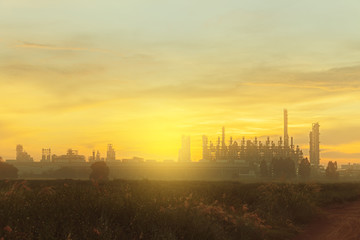 The Silhouette of chemical plant  with meadow at sunrise (select