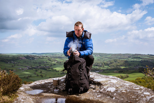 Male hiker with camping stove on top of Guise Cliff, Pateley Bridge, Nidderdale, Yorkshire Dales