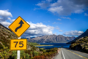 Road sign with mountain and lake on the background.
Lake Hawea in the south island of New Zealand