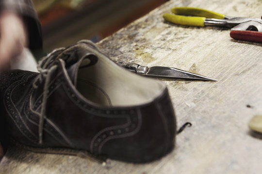 Close up of leather brogue and hand tools in shoe makers workshop