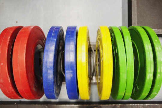 Brightly coloured barbell weights in a row