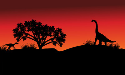 At morning silhouette eoraptor and brachiosaurus
