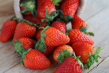 strawberries in small sack on wooden table background