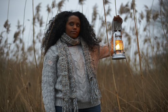 Woman using paraffin lamp in countryside