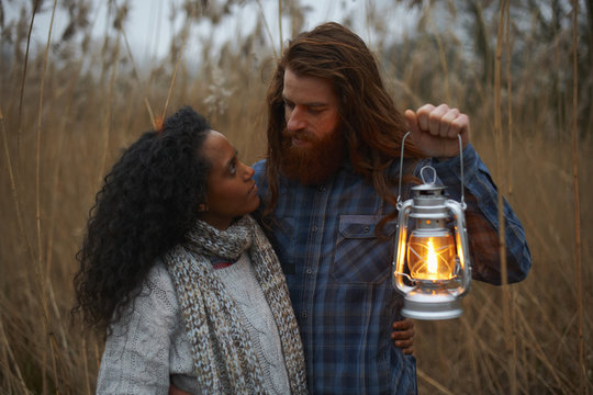 Couple using paraffin lamp in countryside