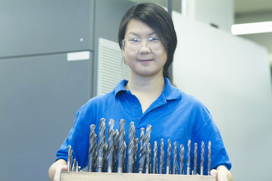 Young woman holding drill bits