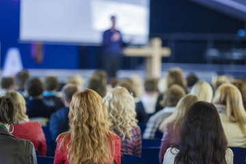 Lecturer Speaking In front of the Large Group of People