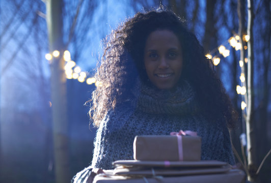 Woman carrying presents to celebration in countryside