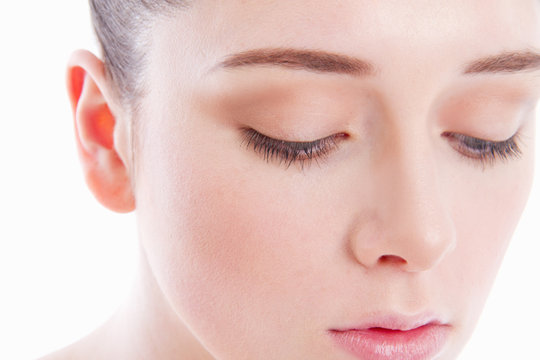 Young woman's face, eyes looking down, close-up