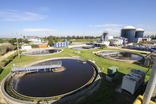 View of sludge treatment pool and storage tanks at sewage treatment plant