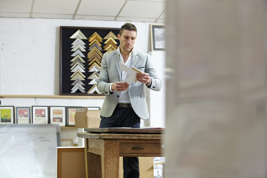 Framer selecting frame in picture framers workshop