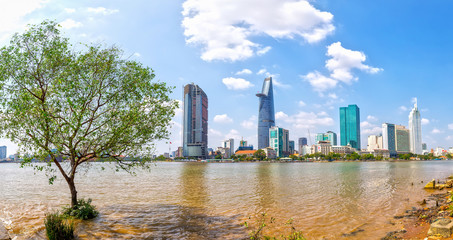 Fototapeta na wymiar Panorama skyscrapers riverside sunny day, in front of riparian cork toward busy urban expressed economic development in opening up Ho Chi Minh city, Vietnam