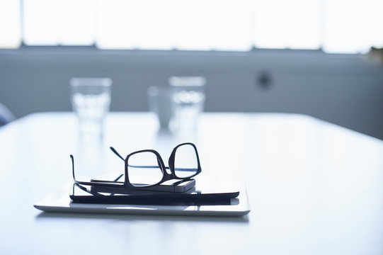 Spectacles, digital tablet and smartphone on conference table