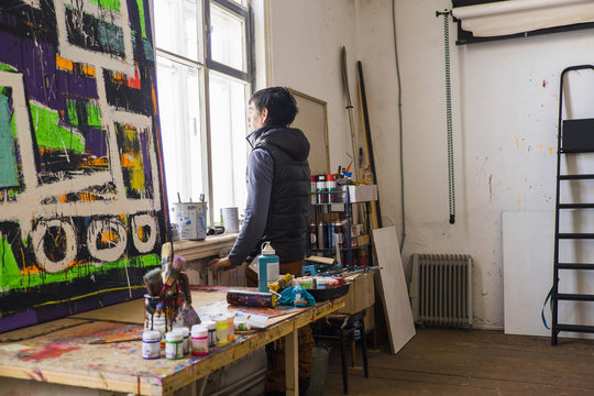 Male artist staring out of studio window