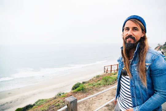 Mid adult man by sea looking at camera