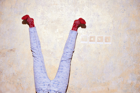 Studio shot of young womans legs upside down against wall