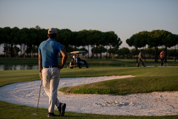 Obraz premium golfer from back at course looking to hole in distance