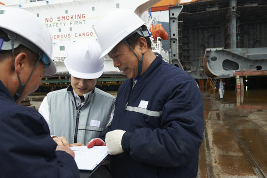 Workers discussing plans at shipyard, GoSeong-gun, South Korea