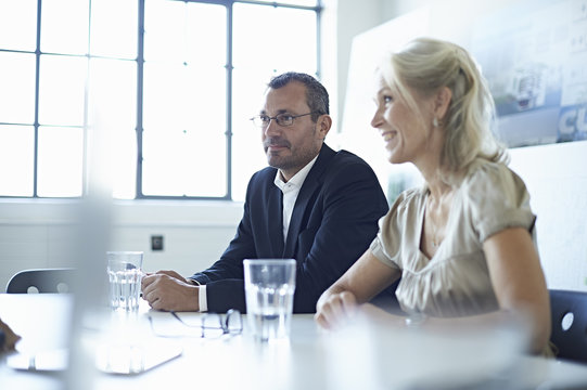 Businesswoman and man at conference table in office meeting