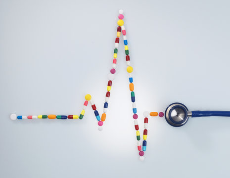 Acoustic stethoscope attached to electrocardiogram of a human heart made up of medicine