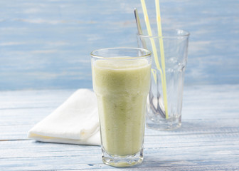 Rhubarb smoothie with a banana on a blue wooden background, selective focus