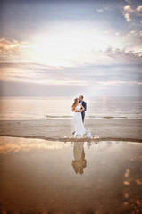 Newlyweds on the beach at sunset