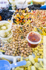 Black, green, red olives, chilies, preserves in a French market in Paris France