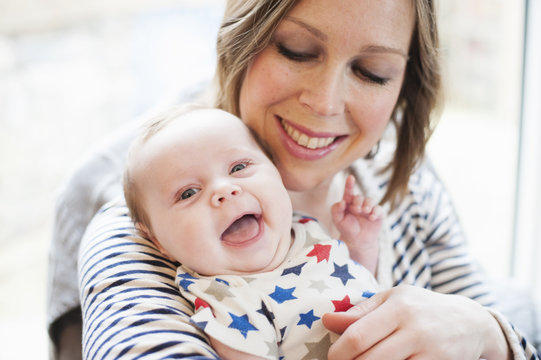 Mother tickling baby daughter