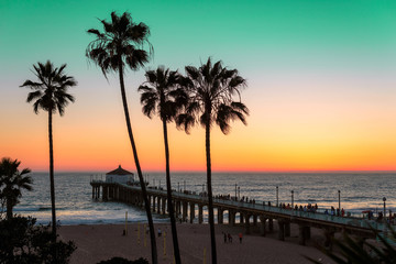 Fototapeta premium Palmy i molo o zachodzie słońca na plaży w Los Angeles. Przetworzone w stylu vintage. Moda podróż i koncepcja tropikalnej plaży.
