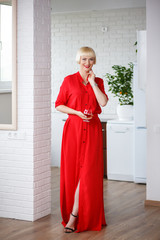 Cheerful woman in red dress with a glass of brandy in his hand s