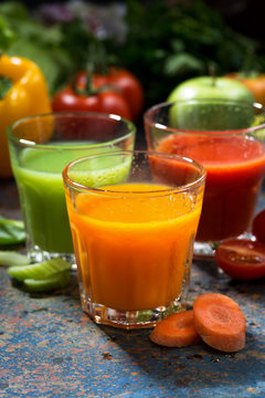 assortment of vegetable juices on a blue background, vertical