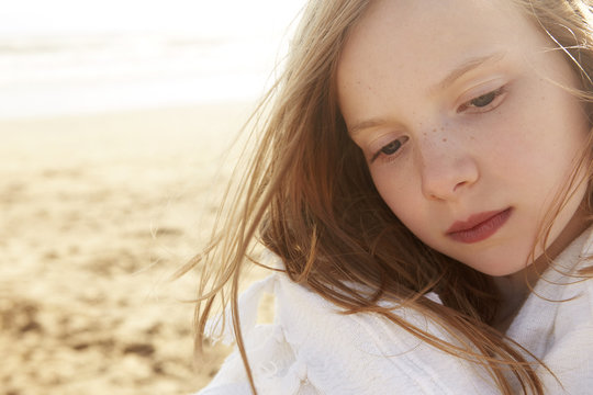 Close up portrait of girl wrapped in blanket on beach