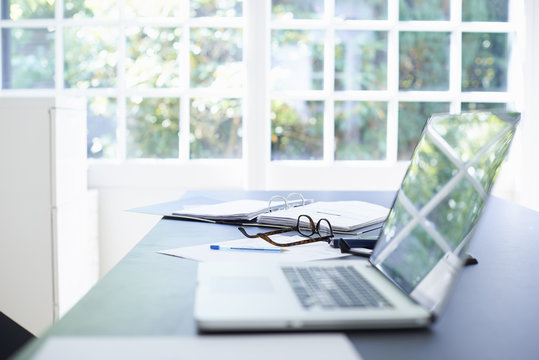 Laptop and diary on dining room table