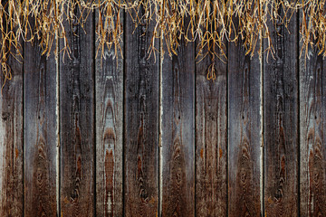 Old wooden fence. Vintage boards and dry grass. Wooden background. Wooden texture.