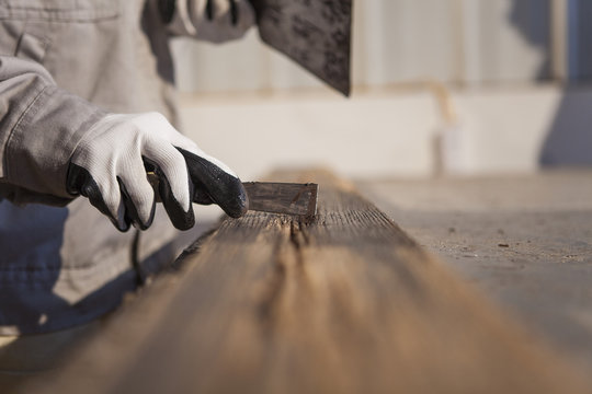 Carpenter scraping wood plank in factory, Jiangsu, China