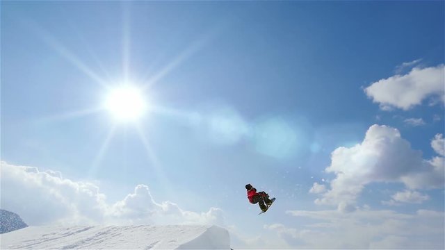 snowboard slow motion,snowboarder jumping spinning backside into the sky