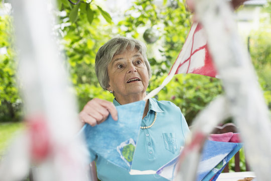 Senior woman hanging up bunting