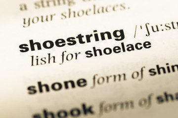 Close up of old English dictionary page with word shoestring