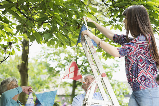 Grandparents and granddaughter hanging up bunting